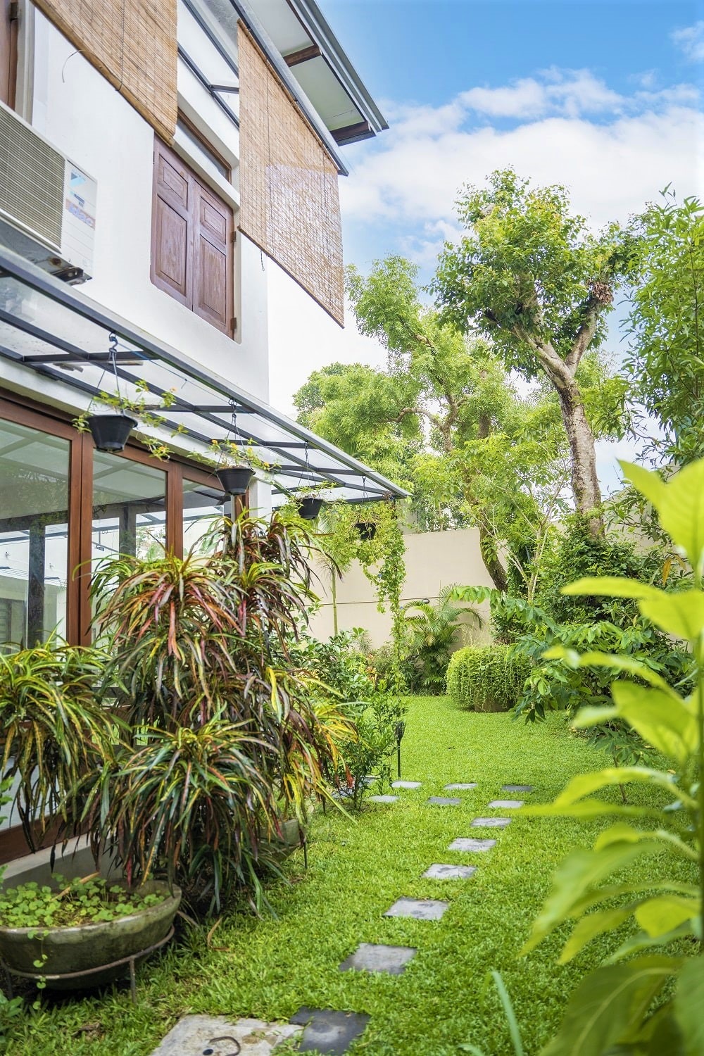 Home garden with big trees, bushes and a lawn